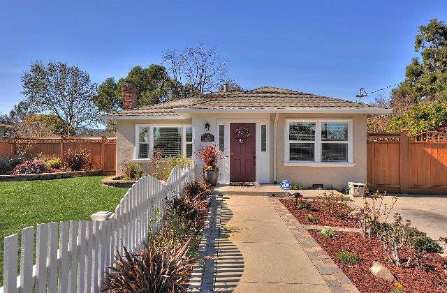 A house with a white picket fence and red door.