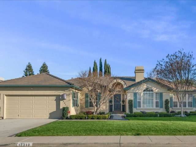 A house with a driveway and lawn in front of it