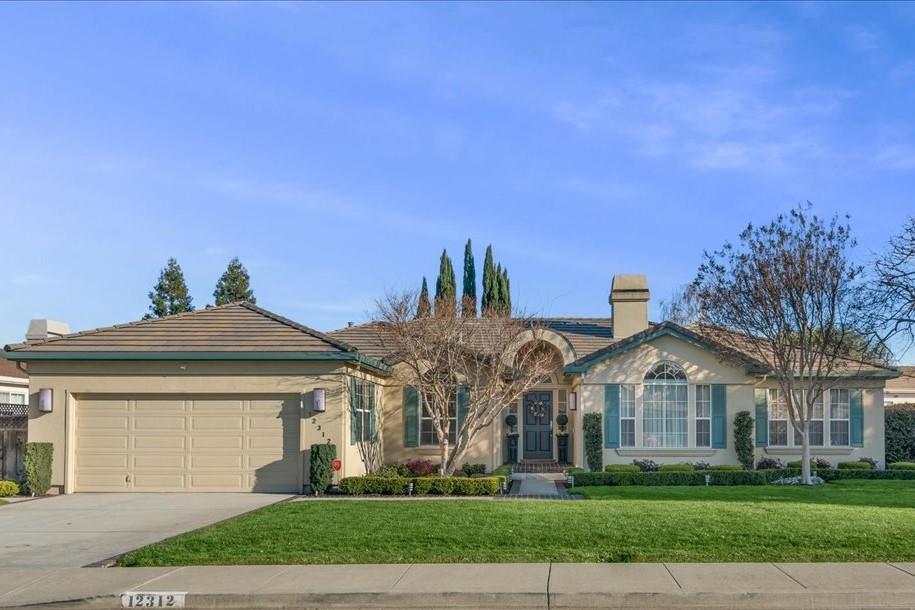 A house with a driveway and lawn in front of it