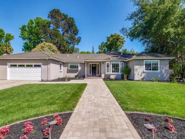 A house with a driveway and lawn in front of it