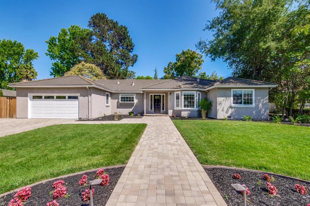 A house with a driveway and lawn in front of it