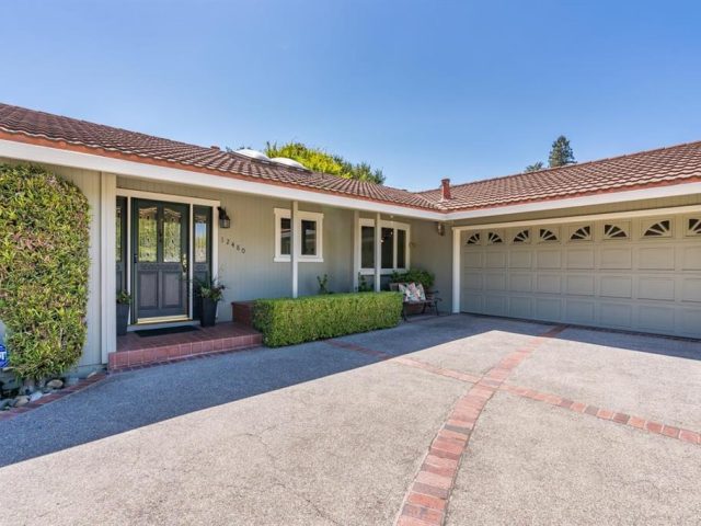 A large driveway with a garage door and brick floor.