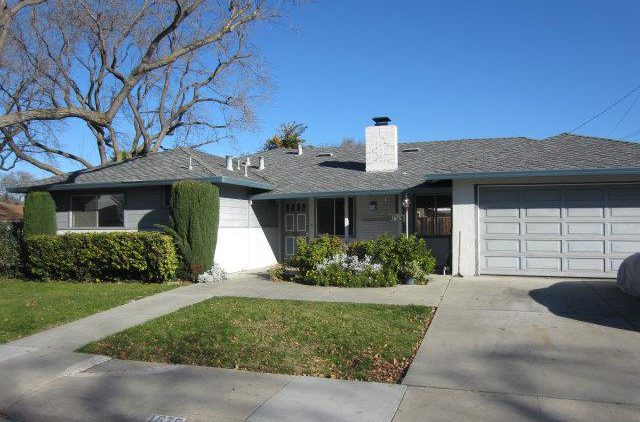 A house with a driveway and lawn in front of it.