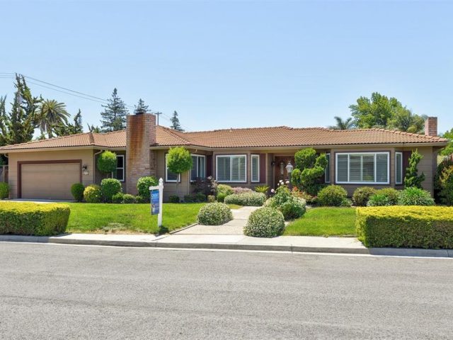 A house with a lot of green grass on the front lawn