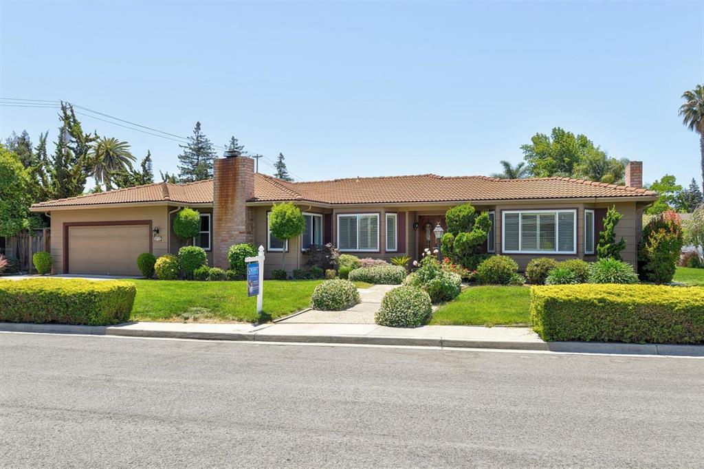 A house with a lot of green grass on the front lawn