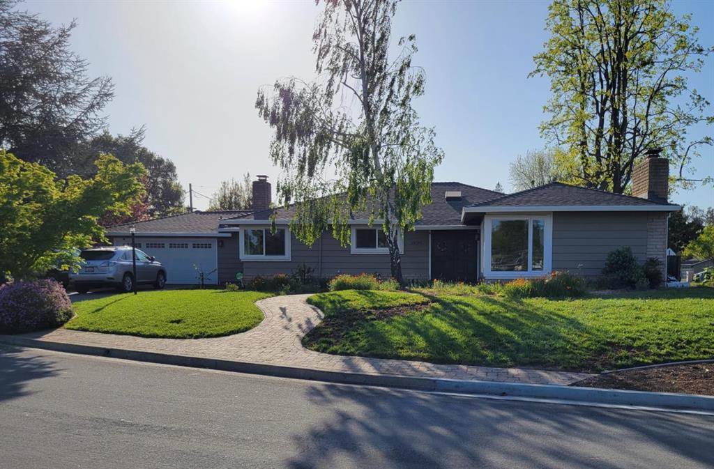 A house with a driveway and trees in the background.