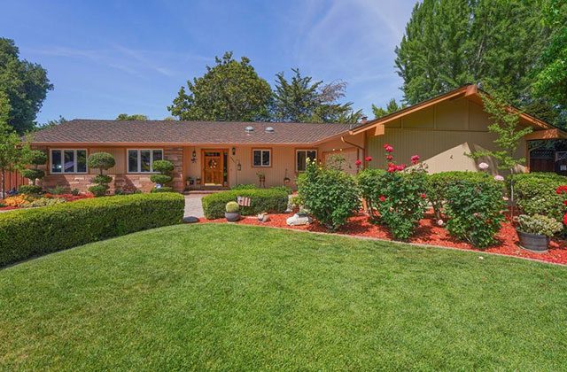 A large yard with a house and bushes