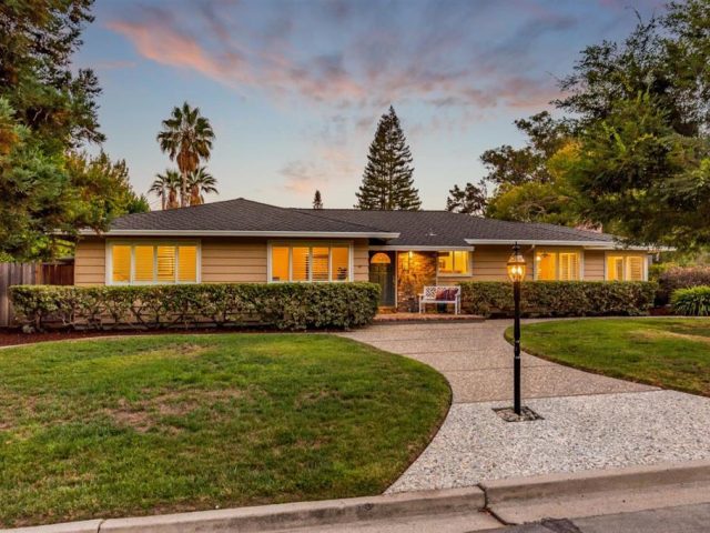 A house with a driveway and lawn in front of it