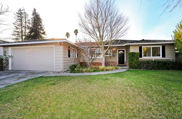 A house with a driveway and lawn in front of it