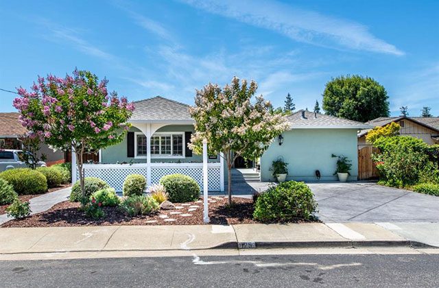 A house with a white picket fence and trees