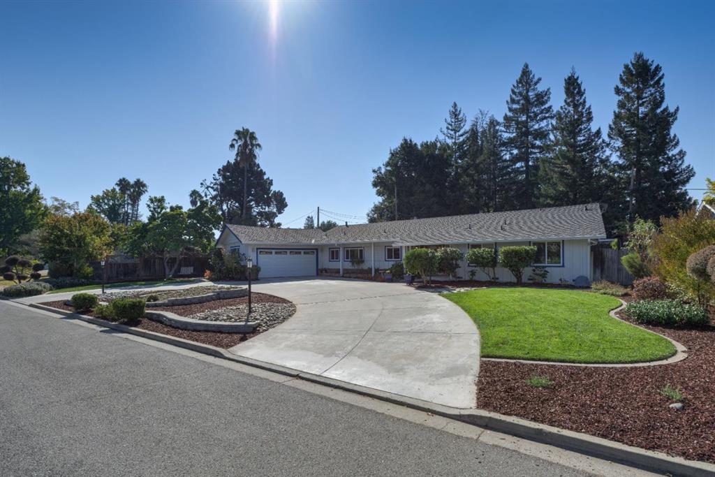 A large driveway with a house and trees in the background.