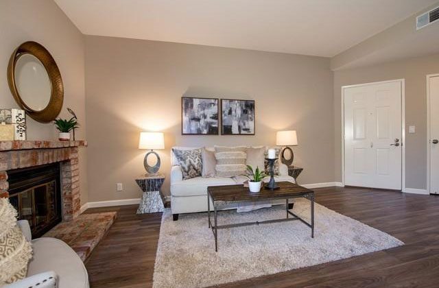 A living room with a couch, table and fireplace.