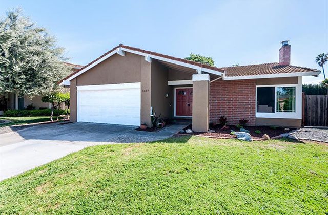 A house with grass in front of it and a white door.