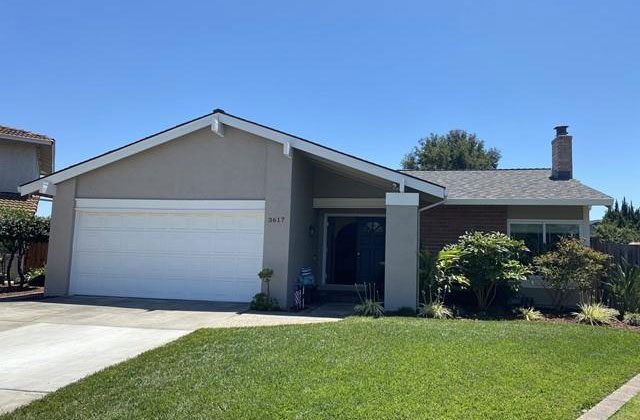 A house with a driveway and garage door open.