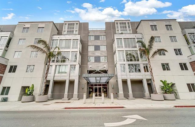 A large building with palm trees in front of it.