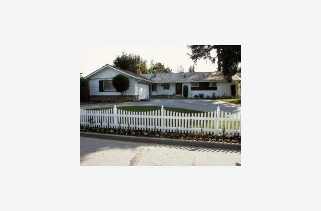 A white picket fence in front of a house.