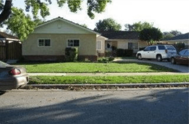 A house with grass on the front lawn