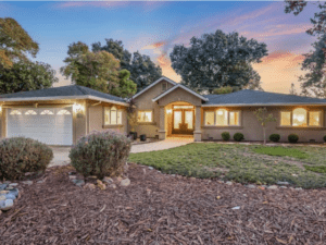 A home with a driveway and trees in the background.